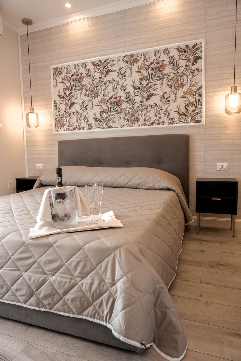 Hotelzimmer mit grau gepolstertem Bett